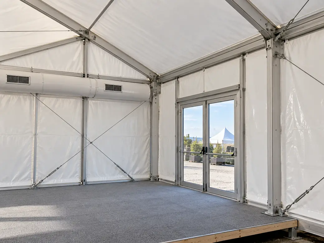 Dettaglio di una tendostruttura con telaio in alluminio, teli in PVC, porta e pavimento